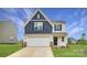 Charming two-story home featuring a two-car garage, and a mix of blue and white siding at 157 Astor St, Troutman, NC 28166