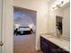 Modern bathroom with marble countertop vanity overlooking into the bedroom at 15708 Eagleview Dr, Charlotte, NC 28278
