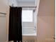 Bright bathroom features a combination shower and tub with a black shower curtain at 15708 Eagleview Dr, Charlotte, NC 28278