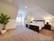 Bright bedroom with a sloped ceiling, a large bed, and a potted plant at 15708 Eagleview Dr, Charlotte, NC 28278