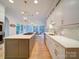 Gorgeous eat-in kitchen with quartz countertops, a central island with cooktop, stainless appliances, and white cabinetry at 15708 Eagleview Dr, Charlotte, NC 28278