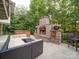 Cozy backyard patio with comfortable outdoor seating, brick fireplace, and hot tub at 15708 Eagleview Dr, Charlotte, NC 28278