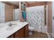 Bathroom featuring vanity with white countertop, matching toilet, and shower with patterned curtain at 15907 Rose Glenn Ln, Davidson, NC 28036