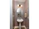 Powder room featuring a pedestal sink, round mirror, and decorative light fixture at 15907 Rose Glenn Ln, Davidson, NC 28036