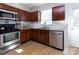 Galley-style kitchen with wood cabinets, stainless steel appliances, and light countertops at 15907 Rose Glenn Ln, Davidson, NC 28036