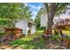 Secluded backyard with a storage shed, wood storage, a bench, mature trees, and well-maintained lawn at 167 Foxtail Dr, Mooresville, NC 28117