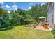 Expansive backyard featuring a deck, patio, garden beds, a wooden pergola, and mature trees at 167 Foxtail Dr, Mooresville, NC 28117