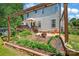 Lush backyard featuring a wooden deck, patio area, garden beds, mature trees, and a fire pit at 167 Foxtail Dr, Mooresville, NC 28117