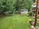 Spacious backyard featuring a shed, bench, mature trees, and lush lawn for outdoor enjoyment at 167 Foxtail Dr, Mooresville, NC 28117