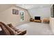 Bonus room with a comfortable leather couch, tv, and bright window for natural light at 167 Foxtail Dr, Mooresville, NC 28117
