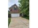 Brick home with a two-car garage, featuring a well-maintained lawn and mature trees at 167 Foxtail Dr, Mooresville, NC 28117