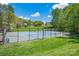 A view of a tennis court in a residential neighborhood with green grass and trees at 167 Foxtail Dr, Mooresville, NC 28117