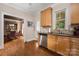 Traditional kitchen features stainless steel appliances, wooden cabinets, granite countertop, and hardwood floors at 1701 Truman Rd, Charlotte, NC 28205