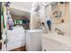 Functional laundry room with washer, dryer, sink, and ample shelving at 1701 Truman Rd, Charlotte, NC 28205