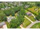 An aerial view of two large homes, a swimming pool, many trees and green lawns at 18733 Bluff Point Rd, Cornelius, NC 28031
