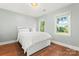 Bright bedroom with hardwood floors, a large bed, and windows offering natural light and scenic views at 18733 Bluff Point Rd, Cornelius, NC 28031