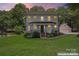 Charming two-story home features a welcoming front porch, complemented by a well-manicured lawn and lush landscaping at 18733 Bluff Point Rd, Cornelius, NC 28031