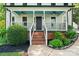 Inviting front porch with ceiling fans, rocking chairs, and brick steps, surrounded by lush plants at 18733 Bluff Point Rd, Cornelius, NC 28031
