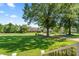 Spacious front yard with lush lawn and mature trees providing shade and curb appeal at 18733 Bluff Point Rd, Cornelius, NC 28031