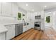 Modern white kitchen with stainless steel appliances, bright countertops, and hardwood floors at 18733 Bluff Point Rd, Cornelius, NC 28031