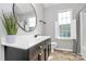 Bathroom featuring a decorative plant next to a dark wood vanity with a sink and a round mirror at 1922 Decatur Ct, Charlotte, NC 28213