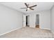 A vacant bedroom shows a ceiling fan, neutral walls, and carpeted floors with an open door at 1922 Decatur Ct, Charlotte, NC 28213