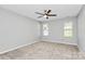 An empty bedroom that features neutral walls, carpeted floors, a ceiling fan, and two windows at 1922 Decatur Ct, Charlotte, NC 28213