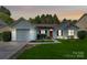 Charming single-Gathering home features a well-maintained lawn, attached garage, and inviting red front door at 1922 Decatur Ct, Charlotte, NC 28213