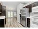Modern kitchen featuring stainless steel appliances and dark wood cabinetry, open to the dining area at 1922 Decatur Ct, Charlotte, NC 28213