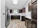 The kitchen features stainless steel appliances, dark wood cabinets, a window over the sink, and wood-look floors at 1922 Decatur Ct, Charlotte, NC 28213