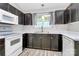 The kitchen features white appliances, dark cabinets, white countertops, and luxury vinyl plank flooring at 1922 Decatur Ct, Charlotte, NC 28213