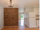 Open dining area featuring hardwood floors, brick accent wall and view to backyard at 214 Cottage Pl, York, SC 29745