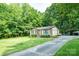 Charming brick home with an orange front door and lush landscaping, nestled in a tree-filled neighborhood at 214 Cottage Pl, York, SC 29745