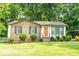 Charming brick home with a tidy lawn, featuring an orange front door and a covered parking area at 214 Cottage Pl, York, SC 29745