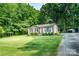 Cozy single-story home with a brick facade, a green lawn, and mature trees at 214 Cottage Pl, York, SC 29745