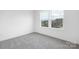 A cozy bedroom features neutral carpet and a window offering neighborhood views at 219 Redondo Dr # 65, Wingate, NC 28174