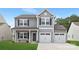Charming two-story home featuring a two-car garage, gray siding, black shutters, and a welcoming front porch at 219 Redondo Dr # 65, Wingate, NC 28174