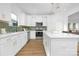 Modern kitchen with white cabinets, stainless steel appliances, stylish backsplash, and wood flooring at 219 Redondo Dr # 65, Wingate, NC 28174