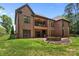 A backyard featuring a fire pit and a multi-level brick house at 2341 Shiny Leaf Dr, Denver, NC 28037