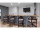 Basement bar with wooden countertop, stylish stools, and a wall-mounted television for entertainment at 2341 Shiny Leaf Dr, Denver, NC 28037