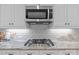 Kitchen stainless gas range and microwave nestled amongst white cabinets and granite countertops at 2341 Shiny Leaf Dr, Denver, NC 28037