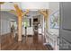 Open-concept living room featuring hardwood floors, stone fireplace, and wood beams at 2341 Shiny Leaf Dr, Denver, NC 28037