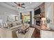 Comfortable living room features a stone fireplace, ceiling fan, and a large window at 2341 Shiny Leaf Dr, Denver, NC 28037