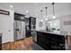 Modern kitchen features stainless steel appliances, dark cabinets, granite countertops, and center island at 246 Bushney Loop, Mooresville, NC 28115