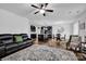 Open-concept living room featuring a leather sofa, stylish rug, and seamless access to the kitchen at 246 Bushney Loop, Mooresville, NC 28115