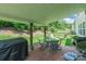 Covered patio features brick flooring, ample seating, a grill, and serene views of the fenced backyard at 261 Catoctin Rd, Rock Hill, SC 29732