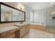 Bathroom featuring soaking tub, double sinks, and separate glass shower with neutral color palette at 300 Wheatberry Hill Dr, Weddington, NC 28104