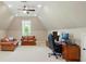 Spacious bonus room with vaulted ceiling features a leather couch, work space, and a view from the arched window at 300 Wheatberry Hill Dr, Weddington, NC 28104