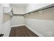 Walk-in closet with custom shelving and storage space with dark wood floor at 300 Wheatberry Hill Dr, Weddington, NC 28104