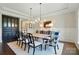 Elegant dining room with a modern chandelier, wainscoting, and stylish seating, perfect for hosting gatherings at 300 Wheatberry Hill Dr, Weddington, NC 28104